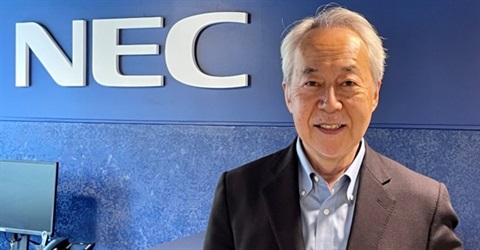 Headshot of Mr. Shin Takahashi standing in front of NEC sign
